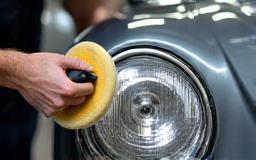 Technician polishing a cloudy headlight to crystal clarity