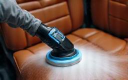 Technician deep-cleaning vehicle seats